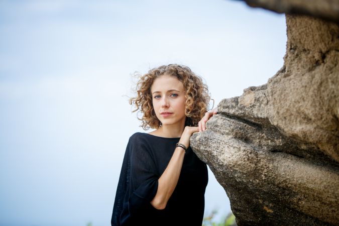 Young woman posing near stone