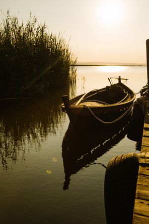Moored boat by wooden pier