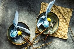 Top view of Easter holiday table setting with blue and yellow egg decorations in bowls