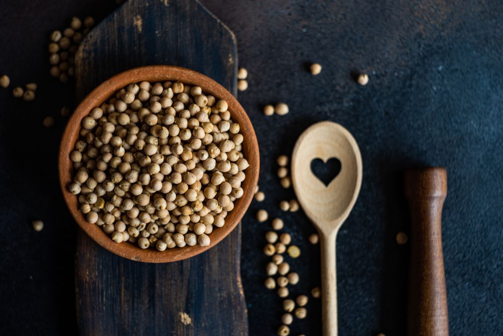 Chick peas in bowl on wooden serving board