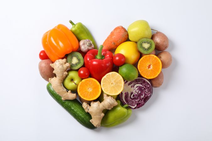 Heart laid out of vegetables and fruits on plain background, copy space