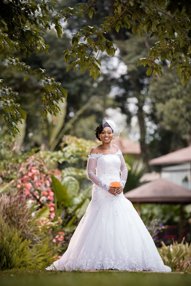 Bride standing beside flowers in a garden