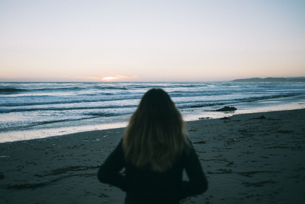 Back of woman walking on beach in California