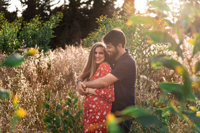 Young happy couple embracing in beautiful garden