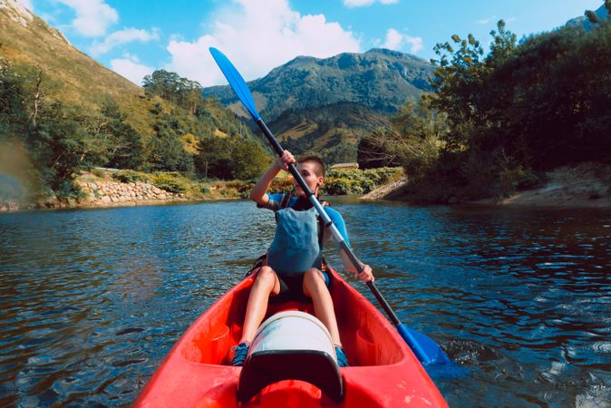 Young female kayaking on nature background