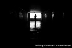 Silhouette of person walking confidently through underground tunnel 5kYKQb