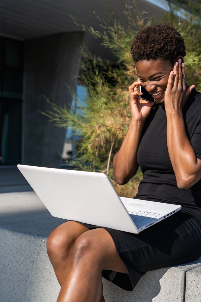 Serious female surfing laptop near modern building