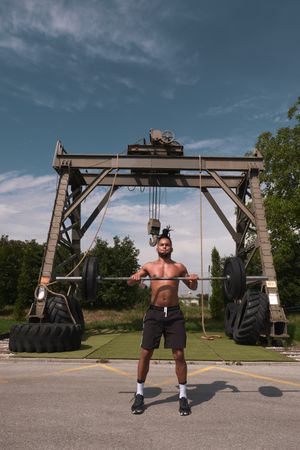Black guy with barbell in outdoor gym