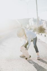 Stylish girl with skateboard on street