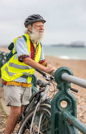 Bearded mature man with bike enjoying coastal view