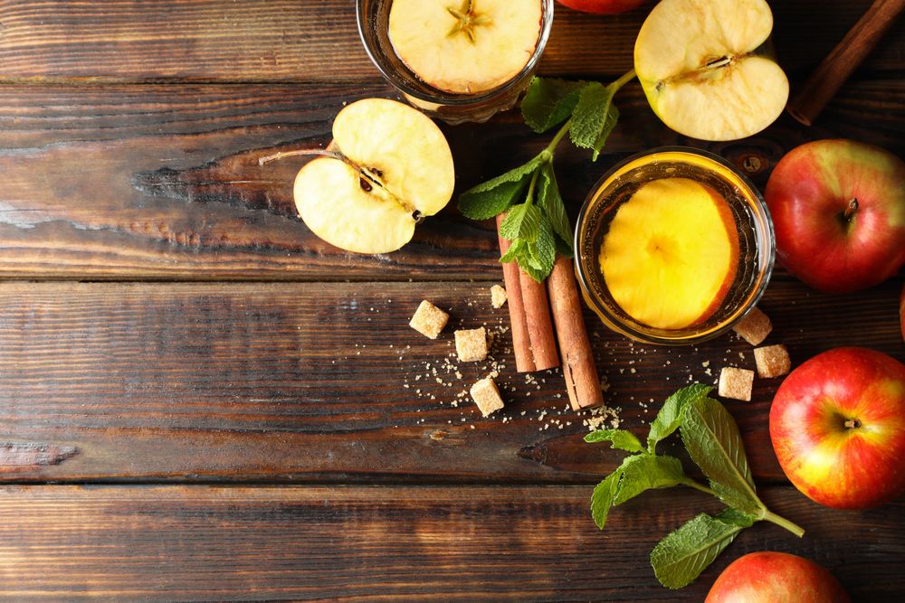 Composition with cider, sugar, cinnamon and apples on wooden table
