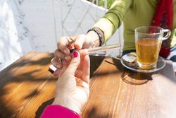 Two women passing a pipe between them