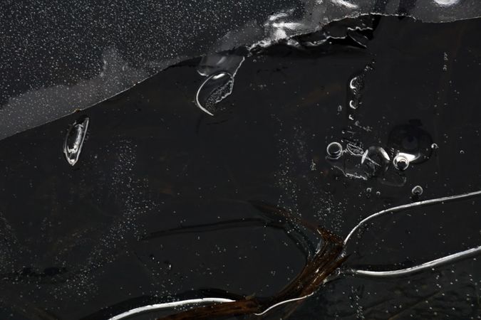Fragment of thin ice on dark frozen river