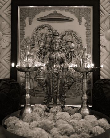 Grayscale photo of Lakshmi golden statue between two Diyas