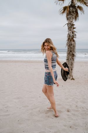 Young female relaxing on beach with hat
