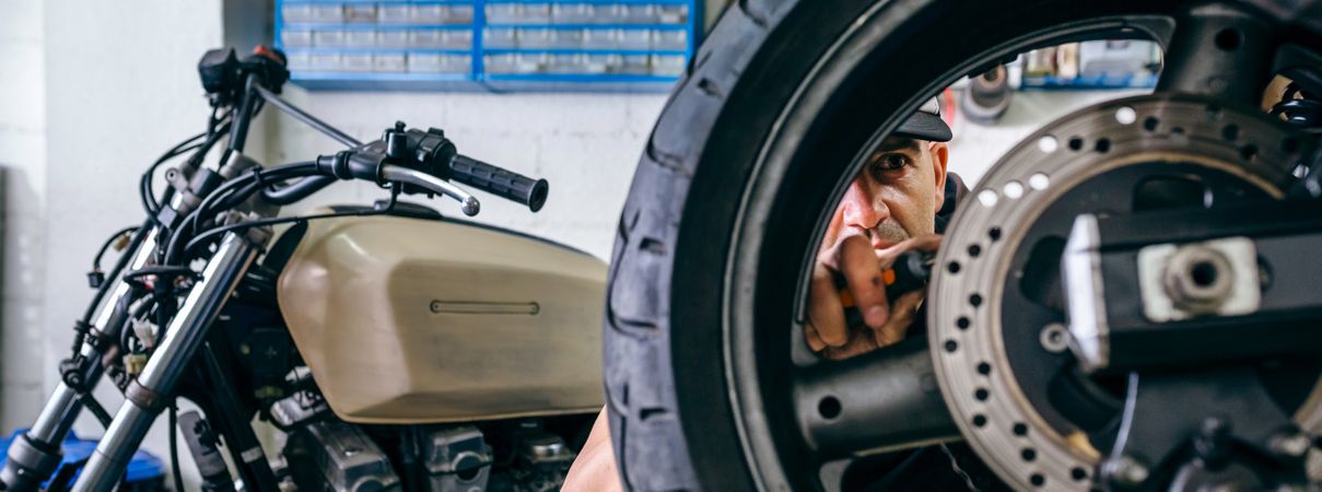 Mechanic fixing custom motorcycle wheel
