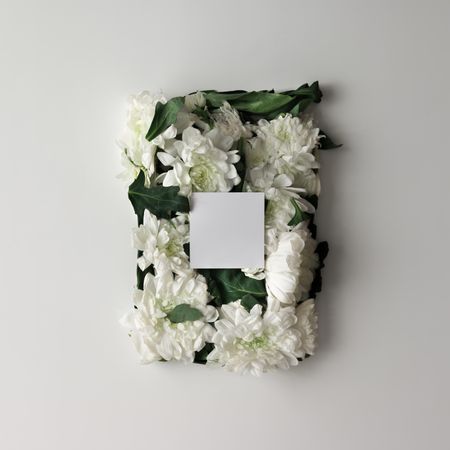 Flowers in shape of a gift box with light  paper card on light background
