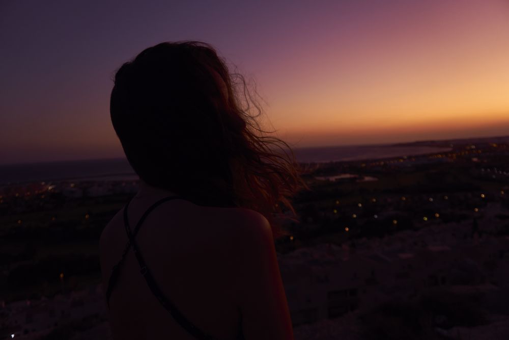 Silhouette of female enjoying picturesque sunset