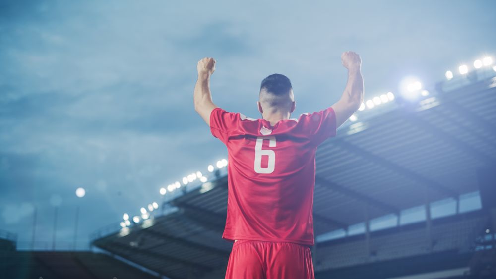 Football Match Championship: Portrait of Handsome Red Team Soccer Player Standing