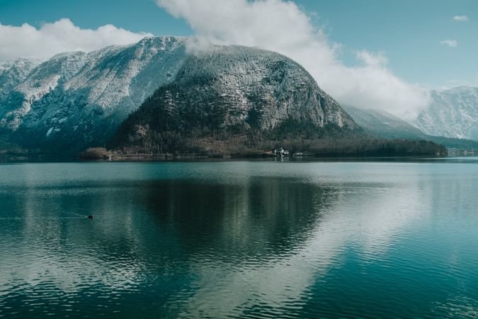 Large snowy mountain surrounded by crystal water
