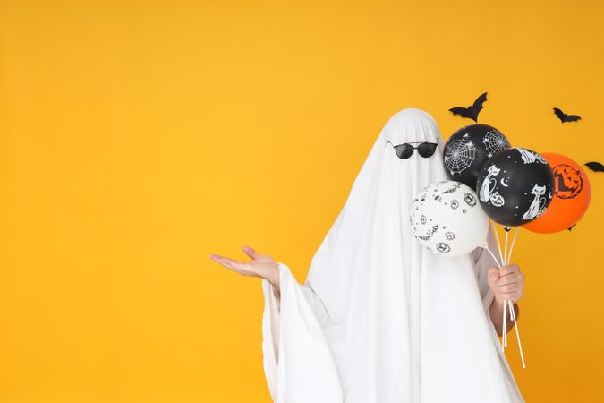 Concept of Halloween, Ghost with balloons on yellow background