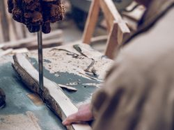 Anonymous craftsman cutting wooden board
