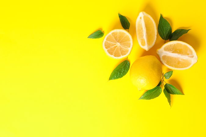 Flat lay composition with lemons on color background, space for text