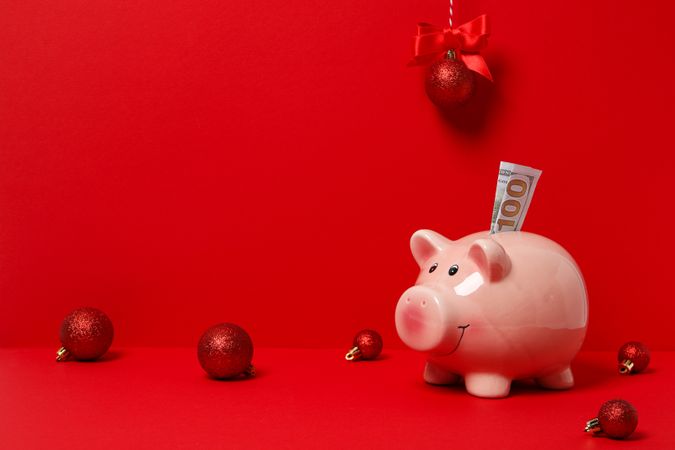 Piggy bank, cash and balls on red background, space for text