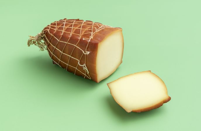 Smoked cheese isolated on green background