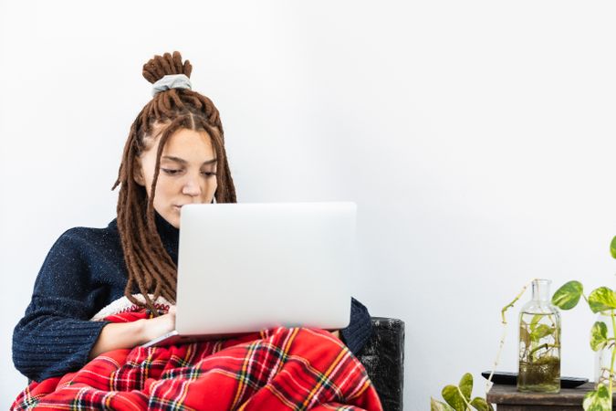 Woman with dreadlocks working with a laptop at home