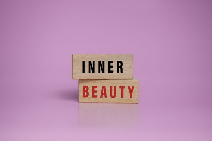inner beauty words on wooden blocks isolated on pink background
