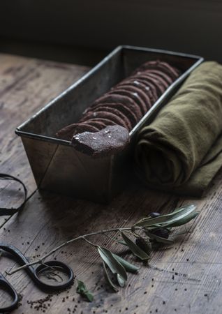 Dry olive twig near chocolate cookies and towel