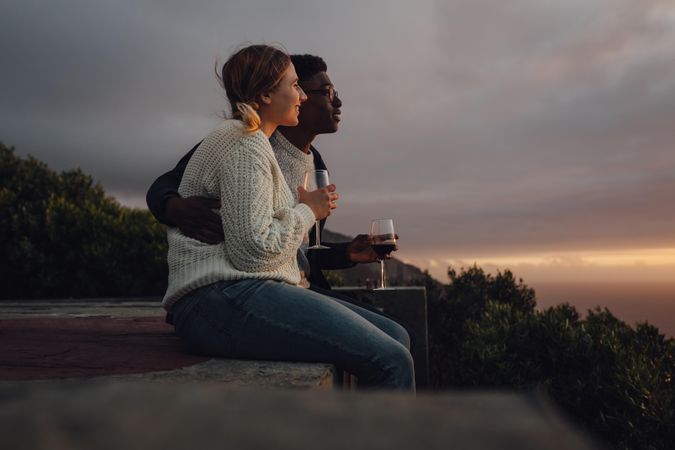 Side view of romantic interracial couple admiring the sunset