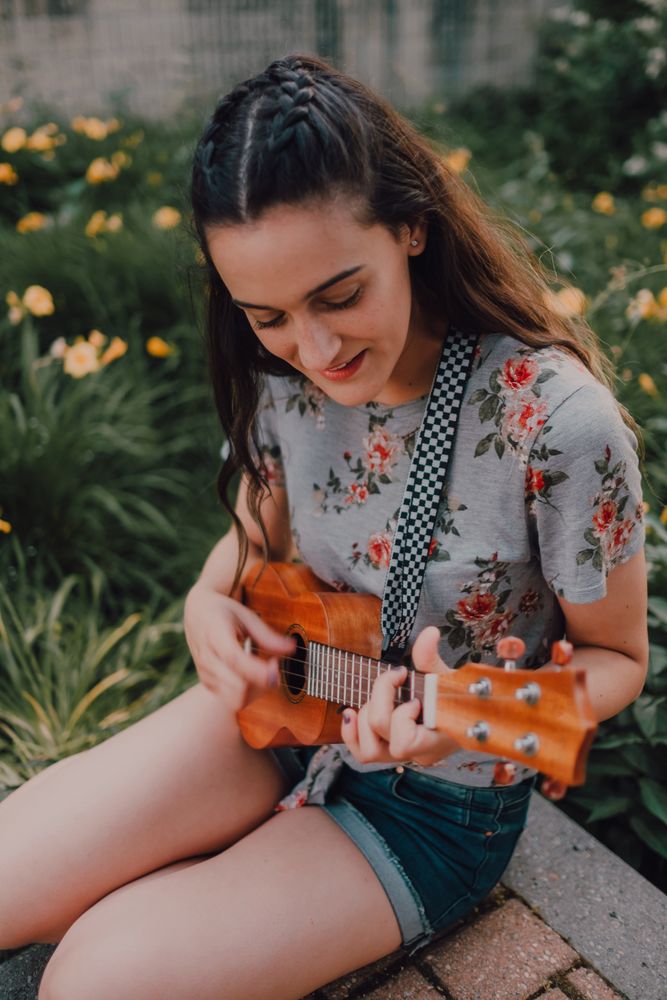 Happy modern woman playing ukulele