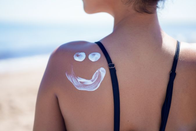 Enjoying a playful Sunscreen application on your face while relaxing on the shoulder at the beach