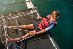 Dreamy kid resting on boat on sunny day