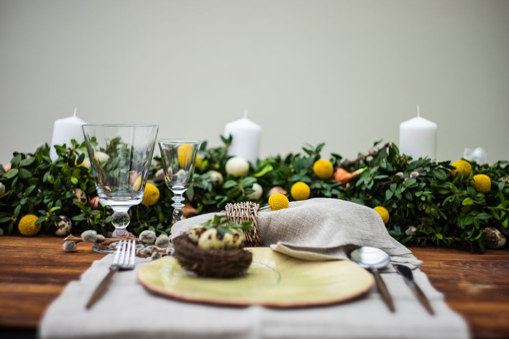 Festive table setting for Easter holiday dinner with bird nest & eggs