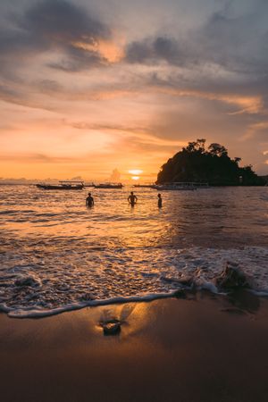 Silhouette of people in the sea during sunset