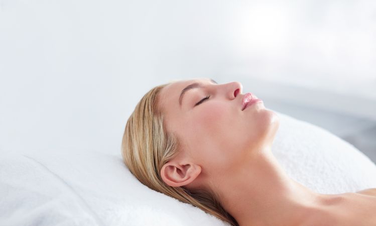 Peaceful woman lying back receiving beauty treatment
