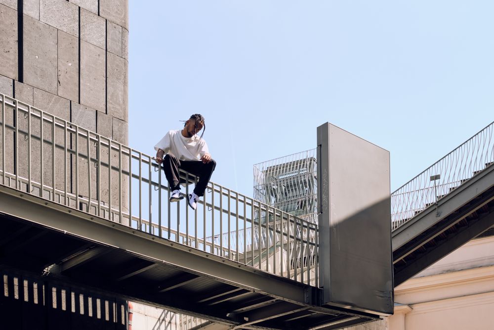 Black male sitting on bridge