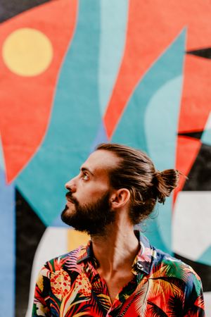 Cool bearded man in bright shirt against colorful wall