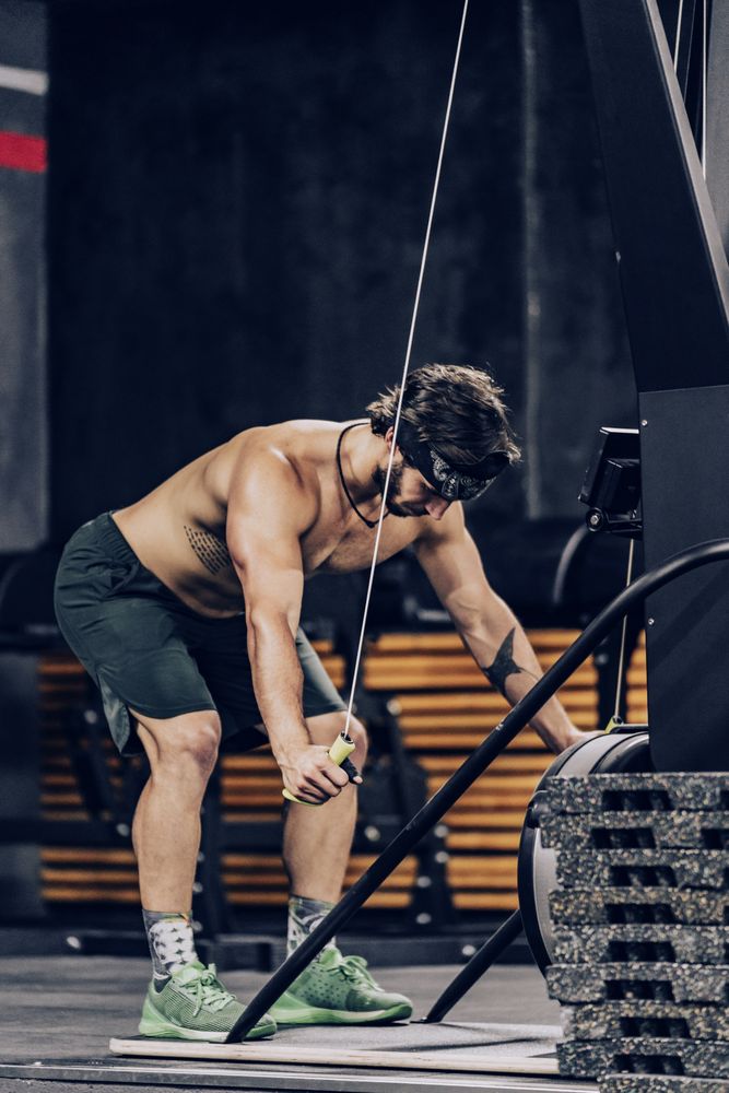 Athletic male pulling ropes in gym