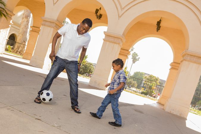 Father and Son Playing Soccer in the Courtyard