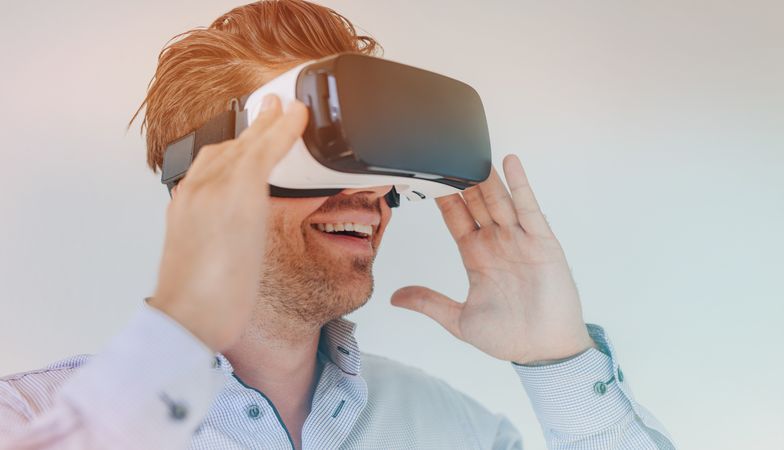 Closeup shot of young businessman using the virtual reality headset and smiling