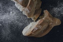Loaf of bread with incisions on grey texture background