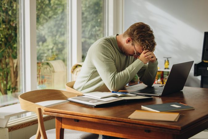 Stressed man feeling overwhelmed working from home