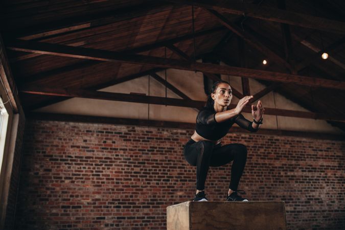 Fit young woman doing a box jump exercise