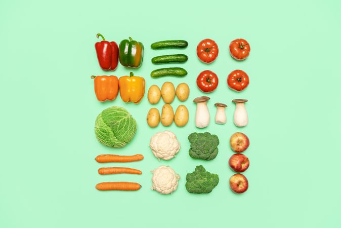 Vegetables and fruits symmetry, isolated on a colored background, top view