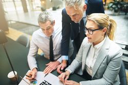 Business professionals focused on a laptop