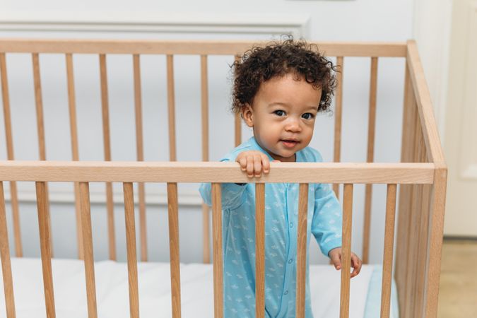 Baby boy standing in crib